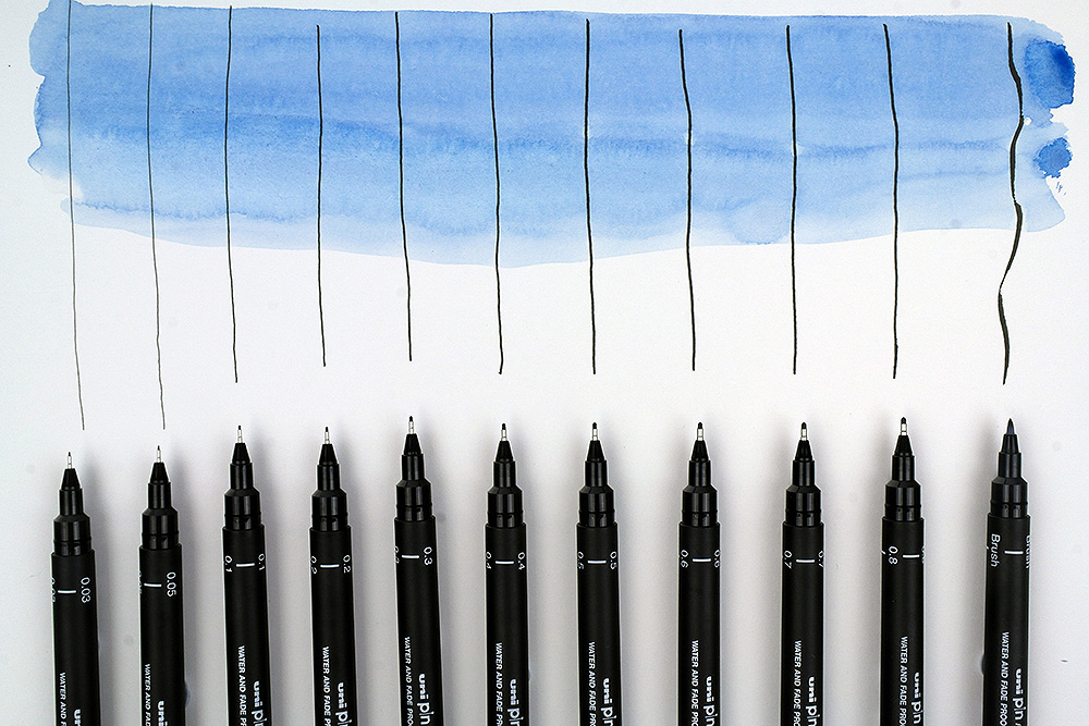 https://www.artsupplies.co.uk/blog/wp-content/uploads/2019/01/UniPin-Fineliners-Group-of-Black-pens-close-up-with-wash.jpg
