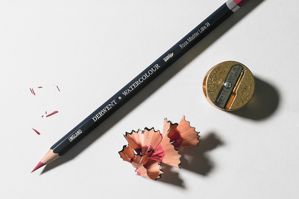 https://www.artsupplies.co.uk/blog/wp-content/uploads/2022/10/A-Derwent-Watercolour-Pencil-with-sharpenings-and-a-brass-sharpener.jpg